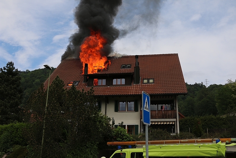 Die Flammen lodern aus dem Dach eines Mehrfamilienhauses in Aeugstertal. (Bild Kapo ZH)