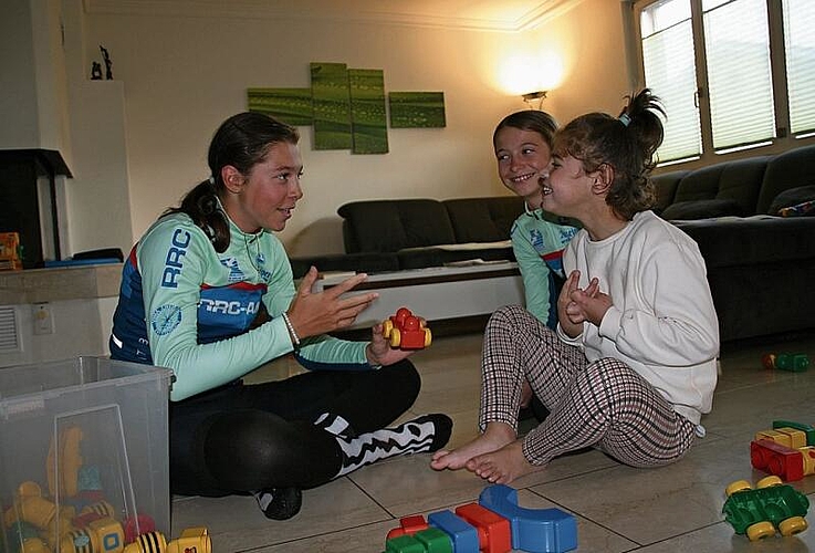 Shana und Lina spielen mit ihrer Schwester Malea im Wohnzimmer Lego.