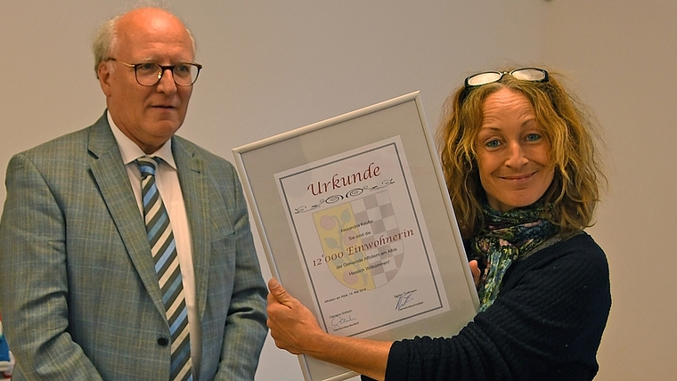 Alexandra Keufer nimmt vom jetzigen Gemeinde- und zukünftigen Stadtpräsident Clemens Grötsch die Urkunde als 12’000. Einwohnerin entgegen. <em>(Bild sals)</em>