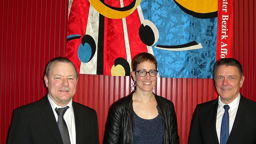 Mit der neuen Aoba-Fahne von links: Präsident Urs Schneebeli, Moderatorin Sidonia Bär und Dirigent René Glauser.
