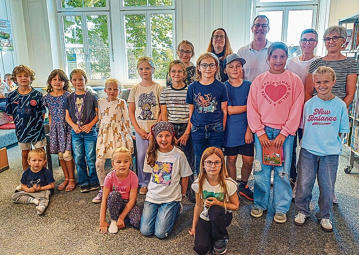 Die beteiligten Kinder und im Hintergrund das Bibliotheksteam (von links) mit Sheila Lanz, Regula Herrmann und Elisabeth Frey. Dazwischen als Vertretung der Kinder-Reha Schweiz Hubertus van Hedel.