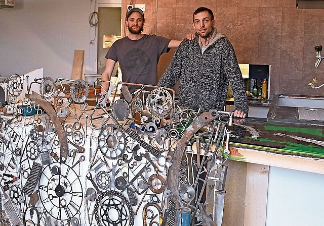 Noch wird fleissig gebaut: Nino Pianezzi (rechts) und Matthias Huber hinter dem künftigen Bartresen, der mit der Verkleidung aus zusammengelöteten Metallelemeneten – eine Eigenkreation – in Szene gesetzt wird. (Bild Livia Häberling)