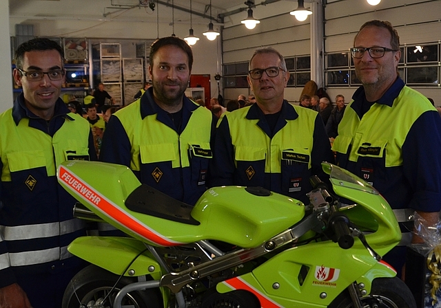 Ein persönliches Feuerwehr-Pocket-Bike für Markus Tschan (2.v.r.). Seine Nachfolge als Kommandant tritt Martin Pfister (2.v.l.) an, Daniel Künzi (links) wird Ausbildungschef, Stefan Kämpfer (rechts) bleibt Vizekommandant. (Bild Thomas Stöckli)