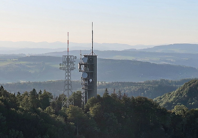 Der Mastturm in schlanker Fachwerk-Konstruktion kommt auf der Felsenegg unmittelbar neben den bisherigen massiven Richtstrahlturm aus Beton zu stehen. (Fotomontage Swisscom Broadcast AG). 
