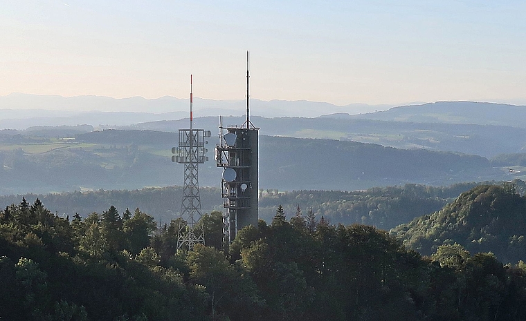 Der Mastturm in schlanker Fachwerk-Konstruktion kommt auf der Felsenegg unmittelbar neben den bisherigen massiven Richtstrahlturm aus Beton zu stehen. (Fotomontage Swisscom Broadcast AG). 