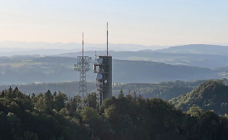 Der Mastturm in schlanker Fachwerk-Konstruktion kommt auf der Felsenegg unmittelbar neben den bisherigen massiven Richtstrahlturm aus Beton zu stehen. (Fotomontage Swisscom Broadcast AG).