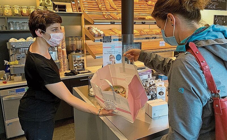Eine Kundin holt sich in der Bäckerei Nussbaumer in Affoltern ein über die App bestelltes Päckli mit Lebensmitteln ab. (Bild Stefan Schneiter)