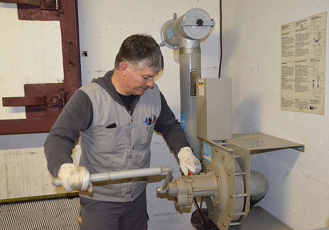 Die Lüftung funktioniert. Schutzraum-Kontrolleuer Fredi Haab testet den Kurbelbetrieb. Im Hintergrund der Notausstieg. (Bild Thomas Stöckli)