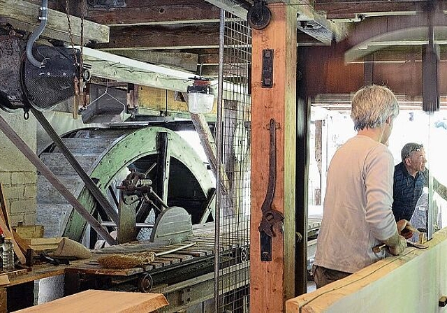 Einheimische Energie verarbeitet einheimische Produkte, im Bild vom Mülitag 2018: Die Säge wird ebenso wie die Mühle im Raum nebenan vom Wasserrad angetrieben. (Bild Bernhard Schneider)