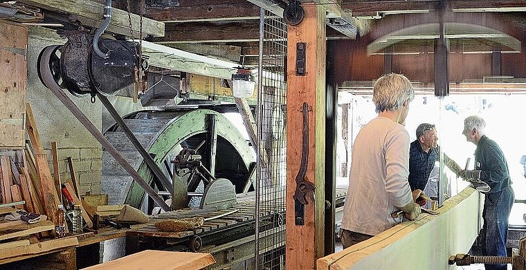 Einheimische Energie verarbeitet einheimische Produkte, im Bild vom Mülitag 2018: Die Säge wird ebenso wie die Mühle im Raum nebenan vom Wasserrad angetrieben. (Bild Bernhard Schneider)