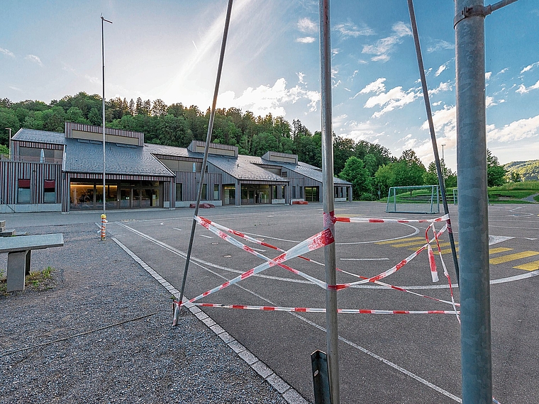 Bauprofilstangen vor der Schulanlage Pünten in Stallikon zeigen die Dimensionen des geplanten Schulhauses und der Sport-/Mehrzweckhalle. (Bild Daniel Vaia)