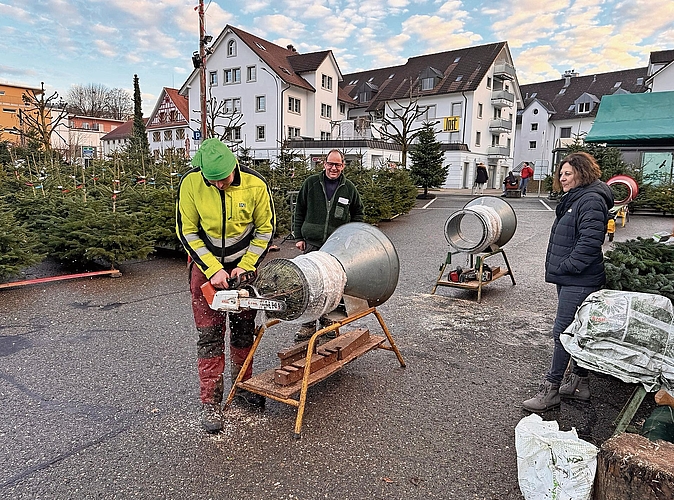 Bereits am Mittwochabend wurden die ersten Christbäume verkauft. Reto Fankhauser macht den Baum gerade für die Kundin bereit. Vater Bruno sieht dem Geschehen zu. (Bild Dominik Stierli) Bereits am Mittwochabend wurden die ersten Christbäume verkauft. Reto Fankhauser macht den Baum gerade für die Kundin bereit. Vater Bruno sieht dem Geschehen zu. (Bild Dominik Stierli)