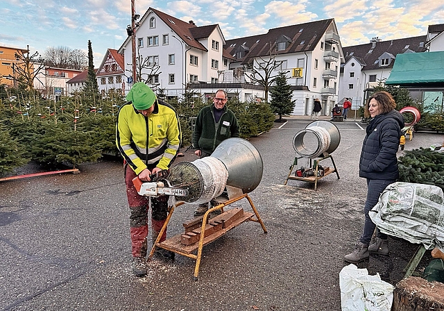 Bereits am Mittwochabend wurden die ersten Christbäume verkauft. Reto Fankhauser macht den Baum gerade für die Kundin bereit. Vater Bruno sieht dem Geschehen zu. (Bild Dominik Stierli)