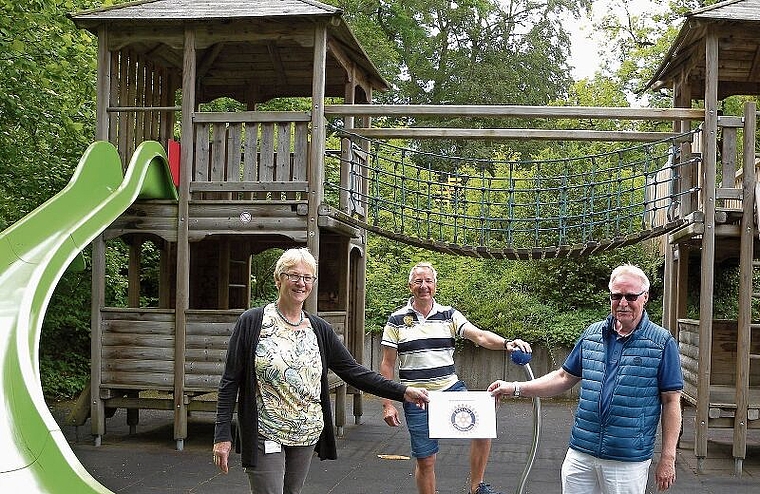 Hans Peter Hefti, Präsident Rotary Club Zürich-Knonaueramt, übergibt auf dem Spielplatz die Spende an Ruth Meierhofer von der Kinder-Reha Schweiz. Im Hintergrund Stephan Jöhl, Jugendverantwortlicher vom Rotary Club. (Bild Marianne Voss)