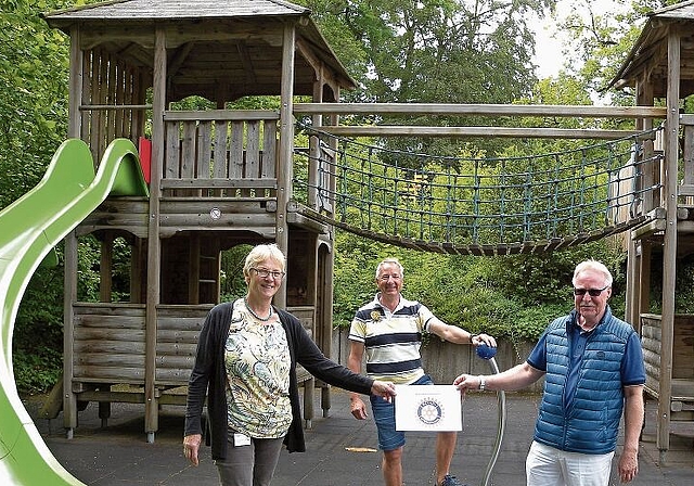 Hans Peter Hefti, Präsident Rotary Club Zürich-Knonaueramt, übergibt auf dem Spielplatz die Spende an Ruth Meierhofer von der Kinder-Reha Schweiz. Im Hintergrund Stephan Jöhl, Jugendverantwortlicher vom Rotary Club. (Bild Marianne Voss)