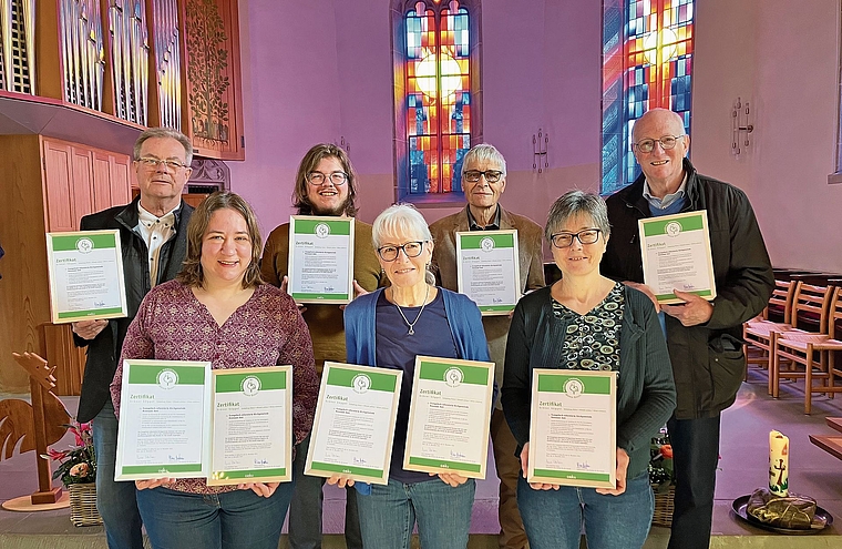 Neun Urkunden für die neun Kirchenorte. Mitglieder der Umweltkommission und Prisca Risold (rechts vorne) mit den Zertifikaten «Grüner Güggel». (Bild Marianne Voss)