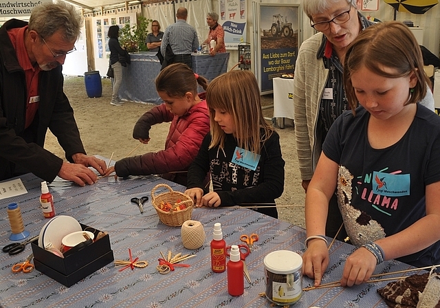 Im Bauernzelt bei Claudia und Ruedi Künzi das Handwerk des Strohflechtens lernen: Kinder stellen «Liebesknoten» her. <em>(Bilder Werner Schneiter)</em>