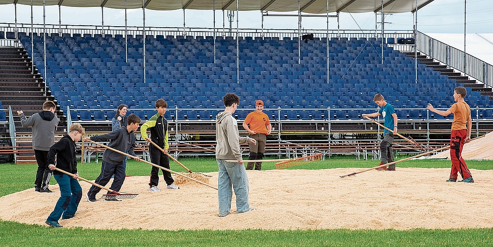 Bessern mit ihrem Einsatz die Klassenkasse auf: Schüler aus Maschwanden beim Verteilen von Sägemehl auf dem Wettkampfplatz. (Bilder Daniel Vaia)