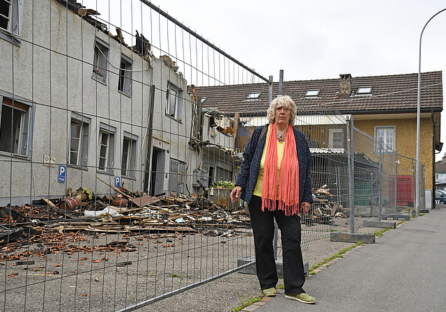 Maya Streich vor dem abgebrannten Haus in Obfelden. Den gelben Hausteil hat sie bis zirka im Jahr 1990 bewohnt. Seit 1999 besitzt sie in Affoltern ein Haus. Auch dieses wurde vor siebeneinhalb Jahren bei einen Brand zerstört. (Bild Livia Häberling)