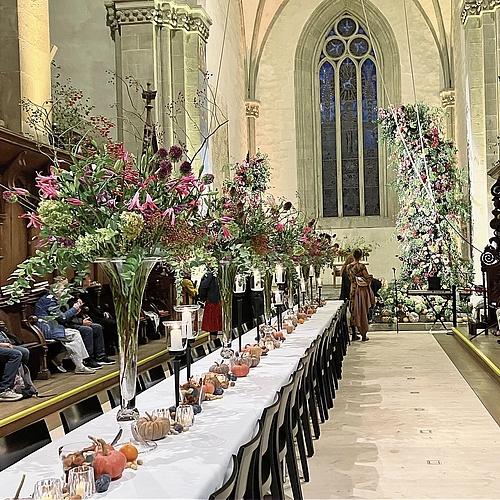 Hohe Blumenbouquets schmücken eine lange Tafel im Kirchenschiff.(Bilder Marianne Voss)