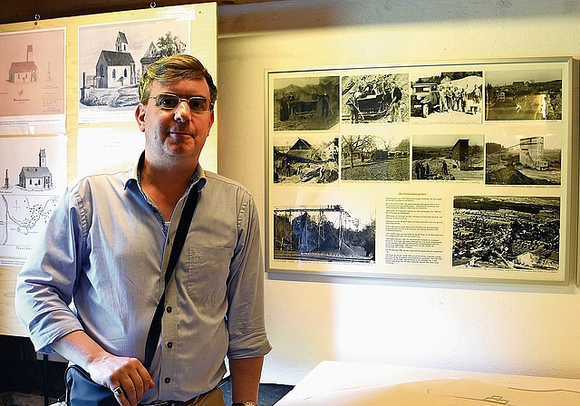 André Gut im Dorfmuseum Maschwanden. Rechts neben ihm befindet sich das von Kaspar Steger gestaltete Archäologiemodell des im 14. Jahrhundert zerstörten Städtchens Maschwanden. (Bild zvg)
