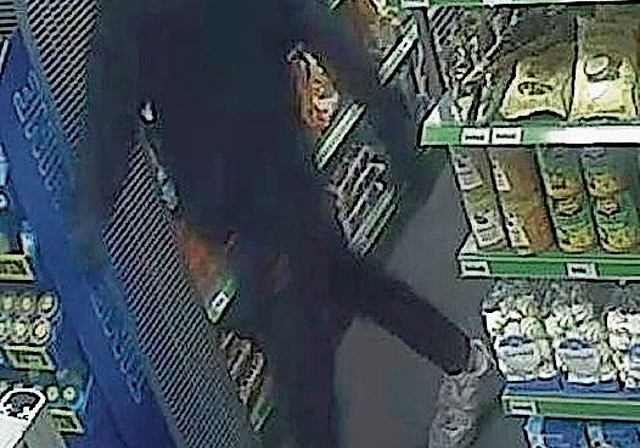 Der maskierte Täter im Verkaufs­geschäft. (Bild Kapo ZH)