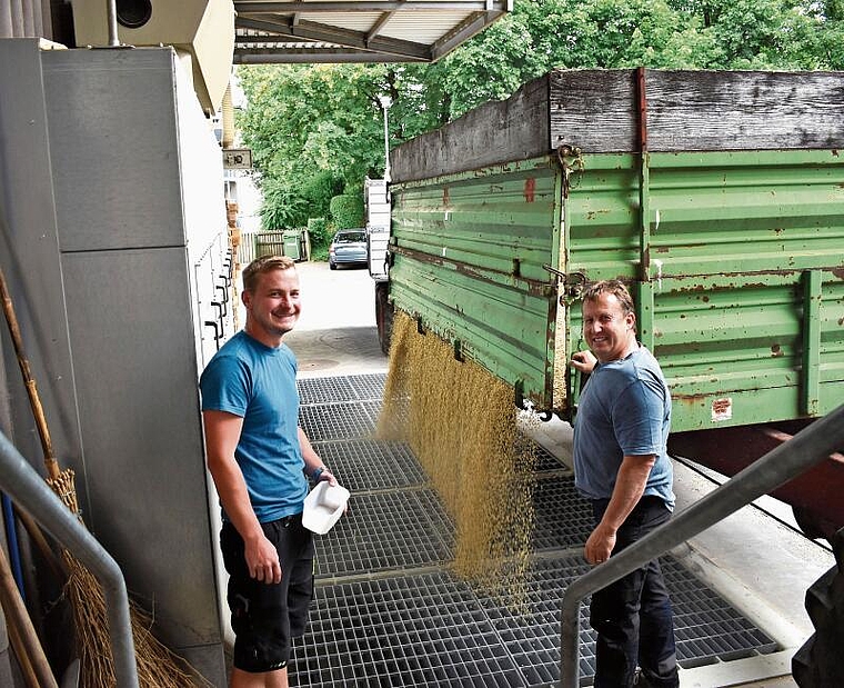 Landwirt Thomas Arnold (rechts) lädt in der Sammelstelle seine Gerste ab.
Links Silochef Jan Burkhard. (Bild zvg)