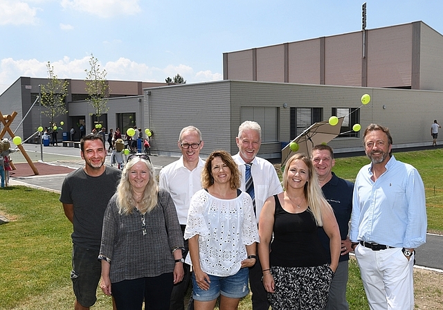 Die Baukommission vor dem sanierten und erweiterten Schulhauses Tömlimatt. Von links Bauleiter Fabio Coluccia, Gemeinderätin Heidi Hui, Bauherrenberater Reto Müller, Schulpflegerin Anette Barili, Gemeindepräsident Kurt Bär, Gemeindeschreiberin S