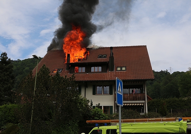 Die Flammen lodern aus dem Dach eines Mehrfamilienhauses in Aeugstertal. (Bild Kapo ZH)
