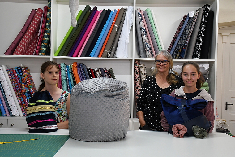 Emilia (links) hat mithilfe von Kursleiterin Hanni Stutz einen Turnsack und ein Blumenkleid genäht, Crisitna einen Rucksack und Haargummis. (Bild lhä)