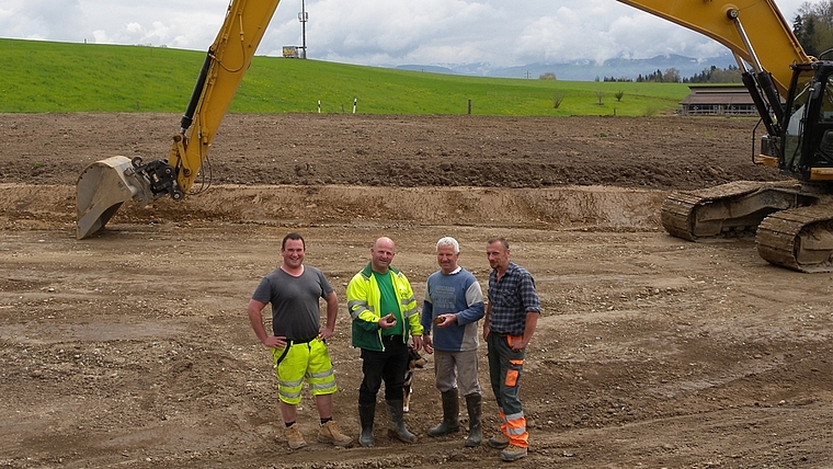 Bodenaufwertung im Uttenberg. Von links: Serge Duperrex, Peter Schmid, Stefan Wüthrich und Jean-Jacques Duperrex stehen auf dem C-Boden. Hinter ihnen Richtung Strasse ist die Schichtung von B-Boden und Humus sichtbar.