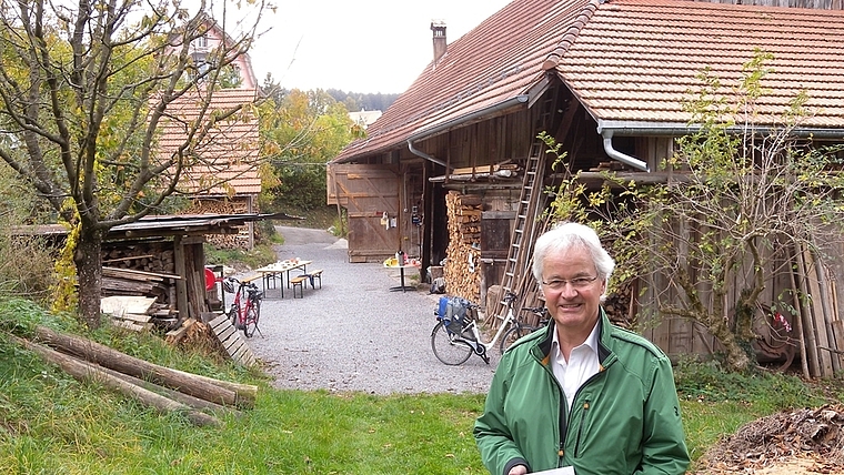 Der Präsident der Stiftung Rotenbirben, Urspeter Sauder, freut sich, die neue Jubiläumsschrift zu präsentieren. Im Hintergrund das Gebäude des altehrwürdigen Hofes. <em>(Bild Marianne Voss)</em>