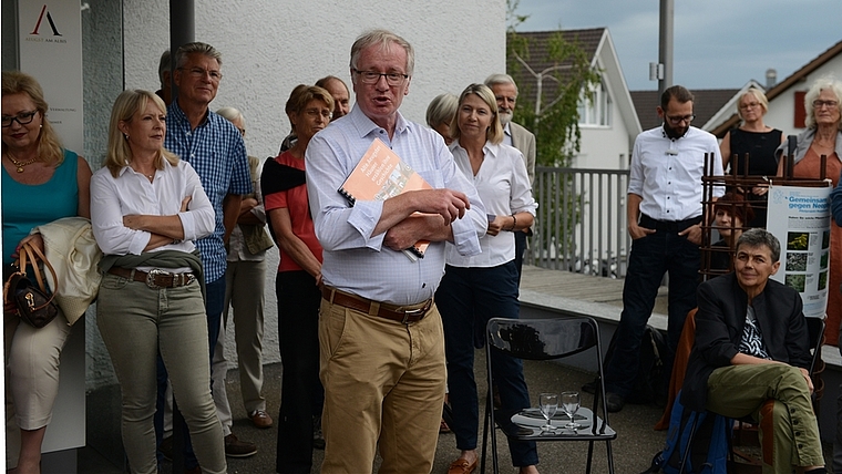 Gemeinderat Bruno Fuchs stellt die Ausstellung auf humorvolle Weise vor. Rechts hinter ihm steht Gemeindepräsidentin Nadia Hausheer. <em>(Bild Bernhard Schneider)</em>