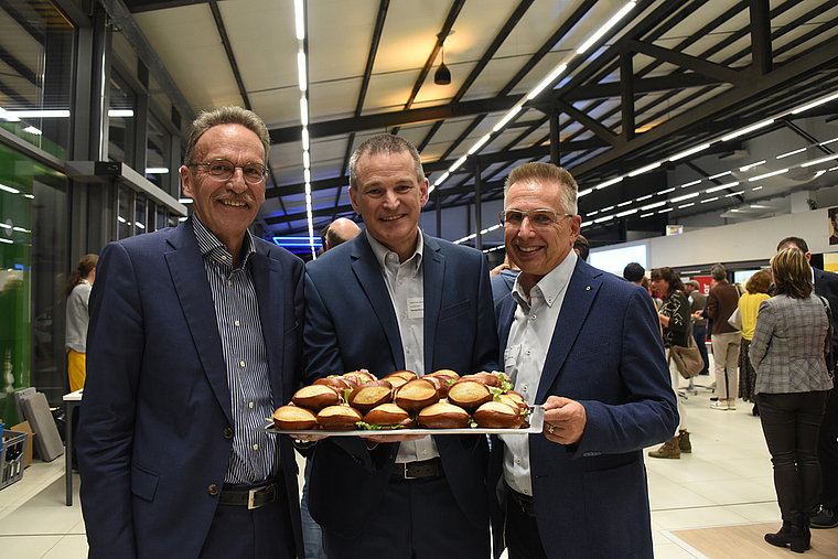 Bevor sie sich bedienen dürfen, müssen Referent Manfred Bötsch, Standortförderer Johannes Bartels und Standortförderungs-Präsident Marcel Strebel (von links) eine der Platten des Apéros riche fürs Foto präsentieren. (Bild Bernhard Schneider)