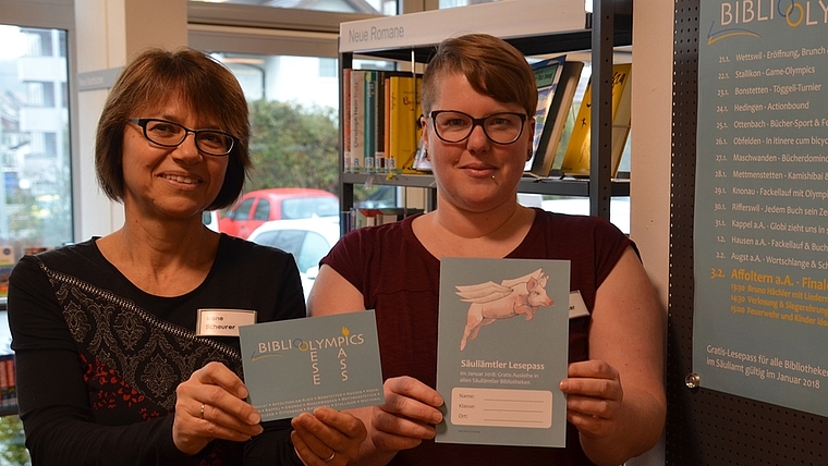 Mit dem Lesepass, den Irene Scheurer (links) präsentiert, lässt sich das Angebot der Ämtler Bibliotheken bis Ende Januar gratis nutzen, Petra Schweizer zeigt die Karte für Kinder, die einen Wettbewerb beinhaltet. (Bild Thomas Stöckli)