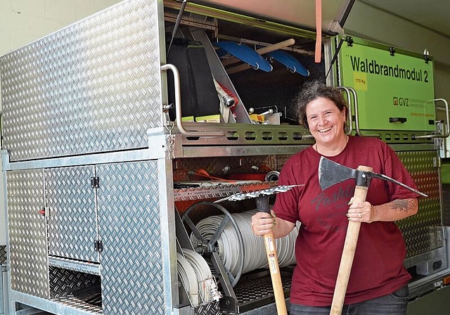 Luana Maggetti, Feuerwehr-Offizierin und Leiterin der Waldbrand-Gruppe in Affoltern, mit dem Waldbrand-Anhänger und den wichtigsten Werkzeugen: Gorgui (links) und Wiedehopf-Hacke. (Bild Thomas Stöckli)