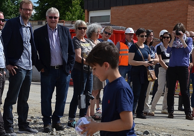 Jede Klasse war am Festakt durch je ein Kind vertreten. Dieses durfte die «Zeitkapsel» der ganzen Klasse zum Grundstein legen. Im Hintergrund von links: Roger Schmutz, Matthias Gretler und Hanspeter Eichenberger. (Bilder Thomas Stöckli)