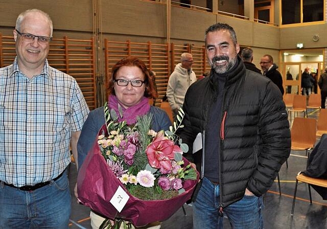 Die erste Gemeindeversammlung in der neuen Legislatur und Blumen für die Leiterin der Kirchenkommission, von links: Gemeindepräsident Christian Bachmann, Sonja Neuweiler und Schulpräsident Ursin Dosch. (Bild Werner Schneiter)