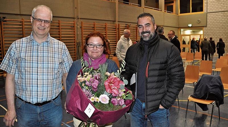 Die erste Gemeindeversammlung in der neuen Legislatur und Blumen für die Leiterin der Kirchenkommission, von links: Gemeindepräsident Christian Bachmann, Sonja Neuweiler und Schulpräsident Ursin Dosch. (Bild Werner Schneiter)