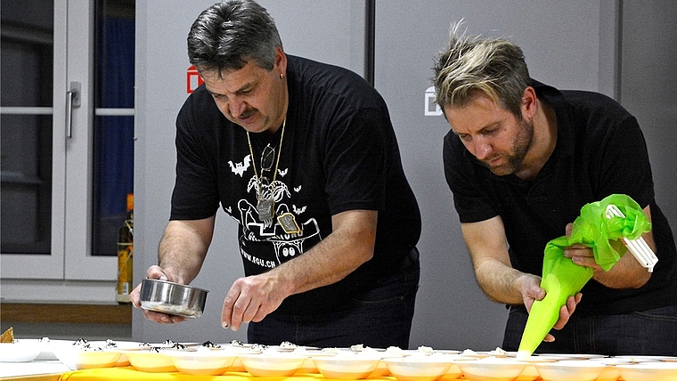 Fasnachts-Action der anderen Art: Vorstandsmitglied Werner Lüthi (links) mit Adrian Müller konzentriert bei der Zubereitung des Desserts. (Bild Martin Platter)