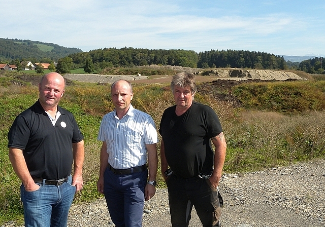 Sie sind erleichtert über das Vorangehen des Projektes. Von links: Peter Schmid, Roberto Molin (Geschäftsführer Peter Schmid Baudienstleistungen AG) und Kari Burkard (Präsident Flurgenossenschaft Hausen). Im Hintergrund die Zwischenlagerung in de