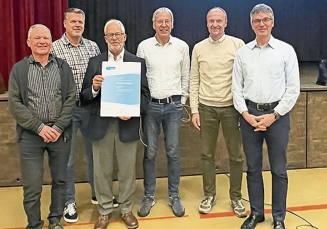 Reihum freudige Gesichter: Heinz Wiher von «Energiestadt» (Dritter von rechts), Ruedi Fornaro, Gemeindepräsident (Dritter von links), Rolf Schilliger, Vorsteher Hochbau & Energie (Zweiter von rechts), und Mitglieder der Energiekommission mit dem e