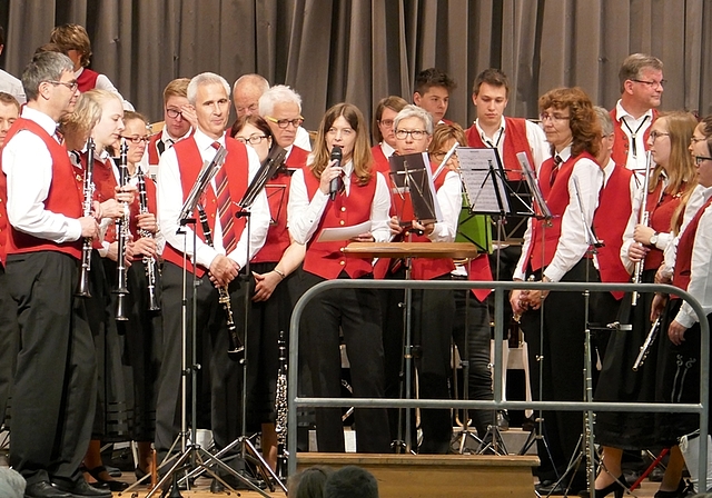 Wenn zwei Musikvereine auf der Bühne Platz finden müssen, bleibt kein Platz für Stühle. In der Mitte mit Mikrofon: Katja Krauer, die den Anlass mit viel Charme moderierte. <em>(Bild Regula Zellweger)</em>