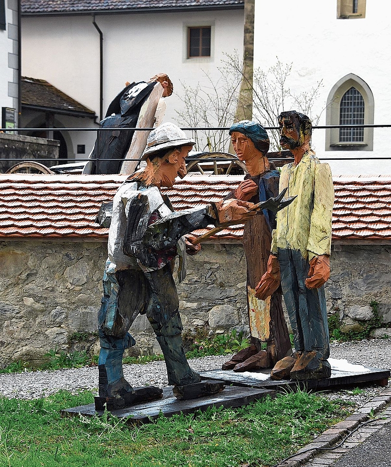 Die Ausstellung Bullinger! mit geschnitzten Holzfiguren des Künstlers Peter Leisinger schmückt bis Juli 2026 das Areal des Klosters Kappel. Auf dem Bild werden zwei Landleute aus dem katholischen Cham gebüsst, weil sie eine Bibelauslegung von Hein