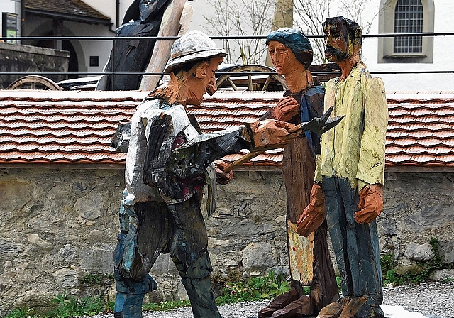 Die Ausstellung Bullinger! mit geschnitzten Holzfiguren des Künstlers Peter Leisinger schmückt bis Juli 2026 das Areal des Klosters Kappel. Auf dem Bild werden zwei Landleute aus dem katholischen Cham gebüsst, weil sie eine Bibelauslegung von Hein