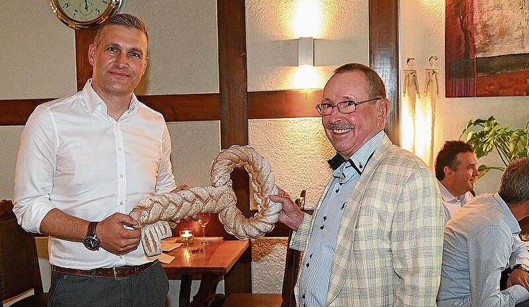 Der neue Präsident, Martin Fröhli (links), erhält von René Homberger einen Schlüssel aus Brot, symbolisch für alle Häuser im Säuliamt. (Bild Martin Mullis)