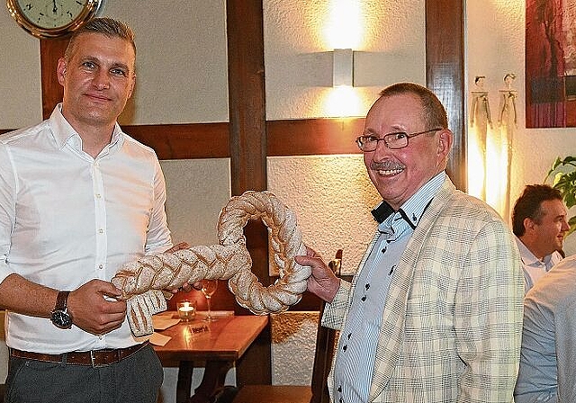 Der neue Präsident, Martin Fröhli (links), erhält von René Homberger einen Schlüssel aus Brot, symbolisch für alle Häuser im Säuliamt. (Bild Martin Mullis)