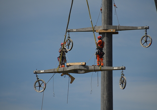 Die Arbeiter werden mit den Auslegern auf den über 30 Meter hohen Mast gehoben. (Bild Salomon Schneider)