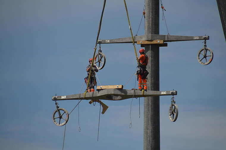 Die Arbeiter werden mit den Auslegern auf den über 30 Meter hohen Mast gehoben. (Bild Salomon Schneider)