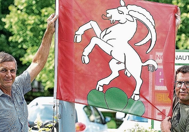 Der Kappeler Gemeindepräsident Jakob Müller, links, und Fahnensponsor Ruedi Berweger hängen eine neue Uerzliker Fahne beim Dorfplatz vis-à-vis des Maxi-Ladens auf. (Bild Martin Platter)